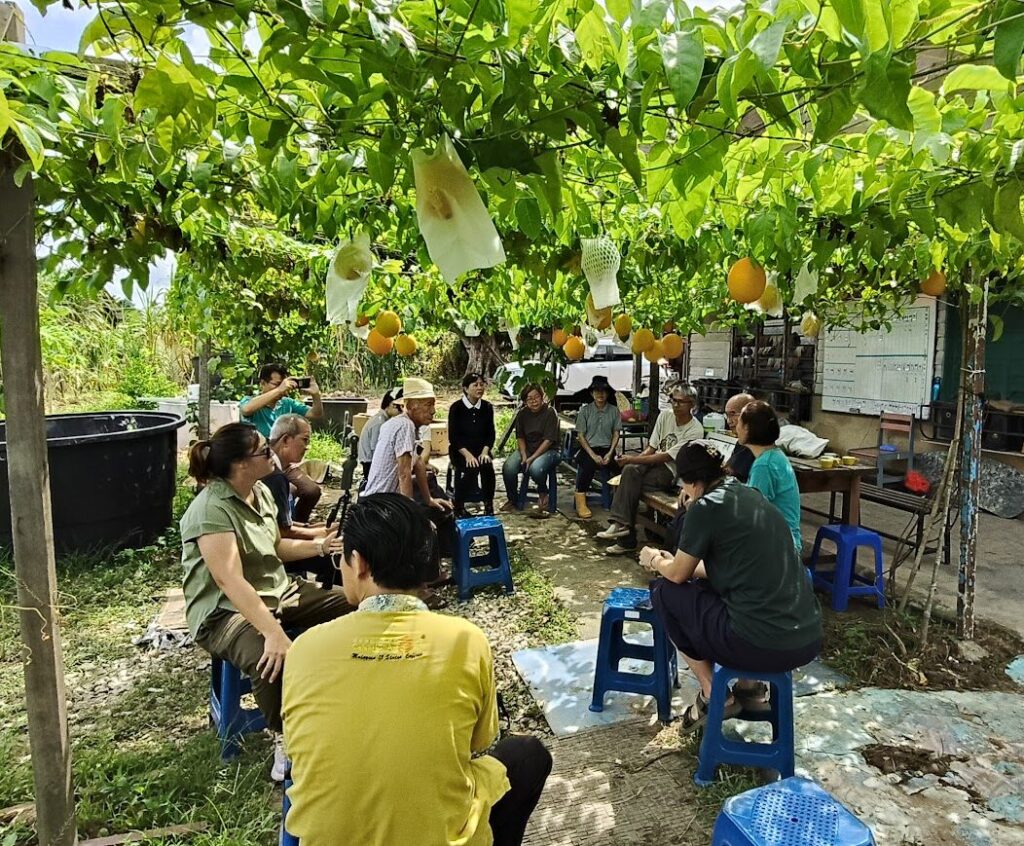 Community members gathering in a regenerative farm environment in Malaysia